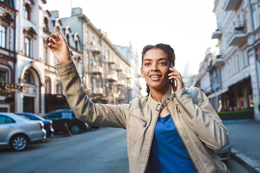 Eine Frau telefoniert, während sie die Straße entlang geht und möglicherweise ein Taxi in Minden herbeiruft.