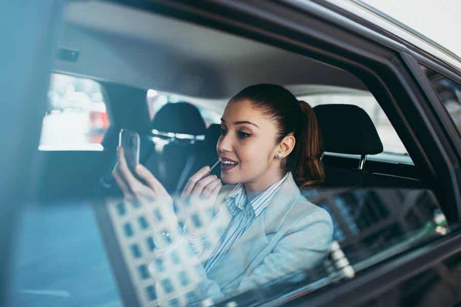 Eine Frau in einem Taxi schaut in Ostfildern auf ihr Handy.