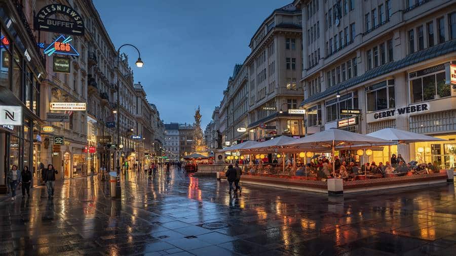 Eine nasse Stadtstraße in der Abenddämmerung, während Taxis durch das pulsierende Vaihingen an der Enz düsen.